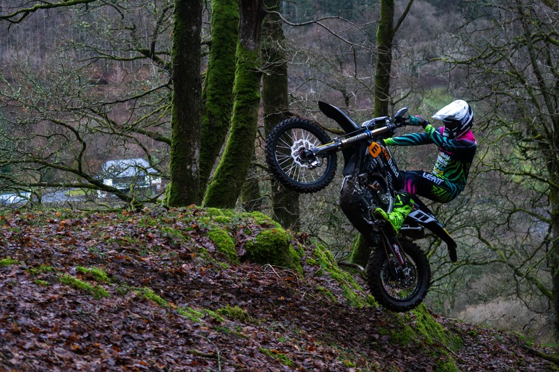 Enduro rider lifting the front wheel in woodland
